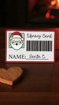 Santa library card sticker featuring a cozy Christmas reading scene, perfect for book lovers and librarian gift ideas.