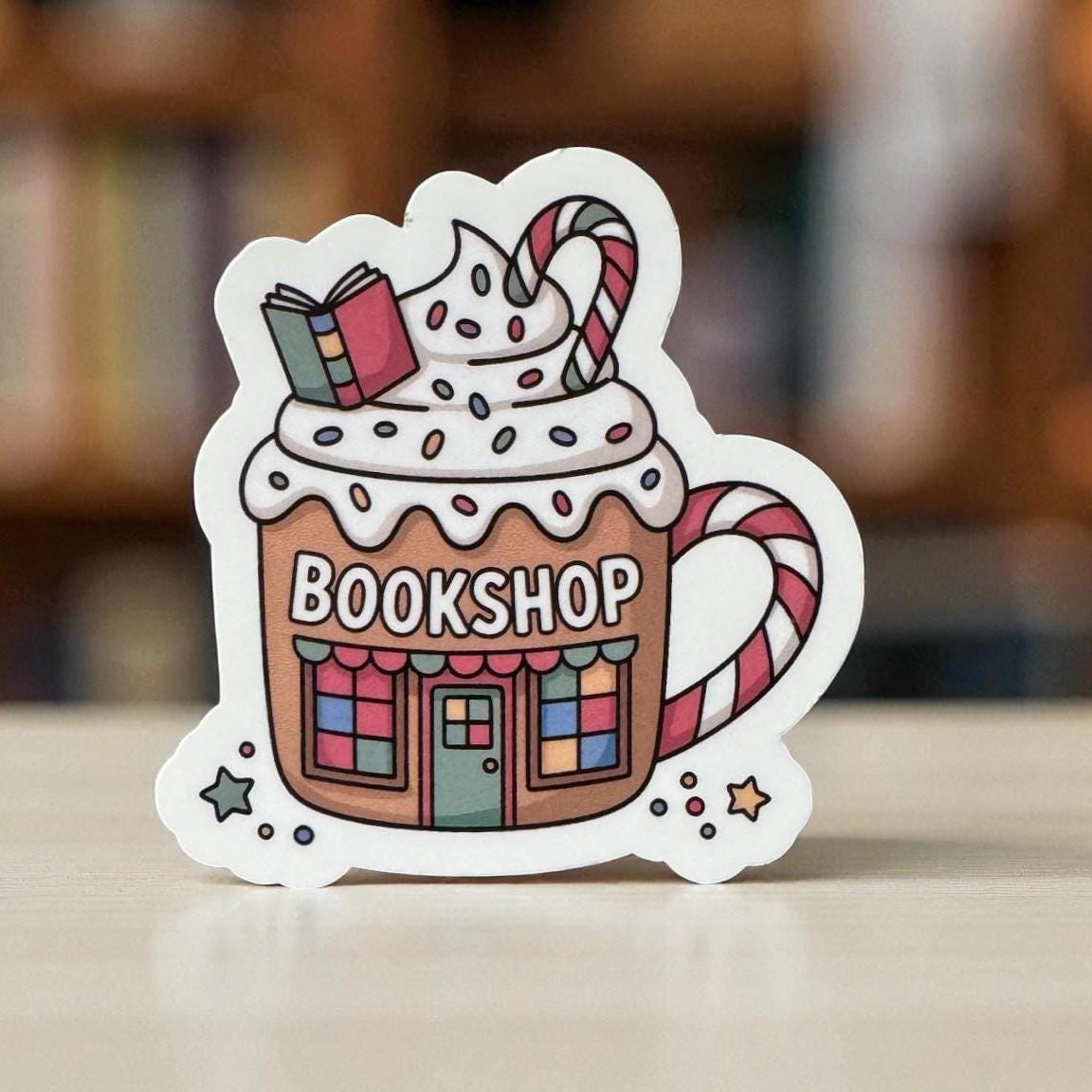 Forcebuilder Bookshop Holiday Mug Sticker featuring Christmas books, candy canes, whipped cream, perfect for cozy book lover decor
